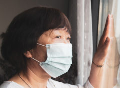 Masked Woman Looking Out the Window